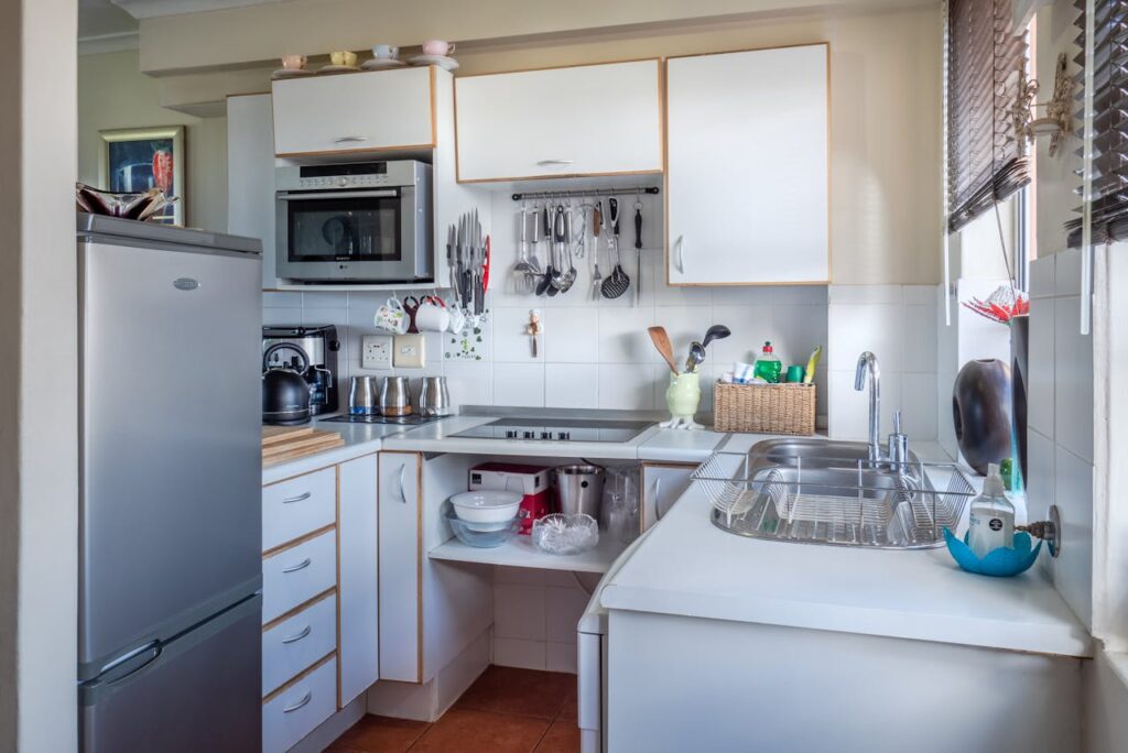 A small kitchen with white wooden cabinets.