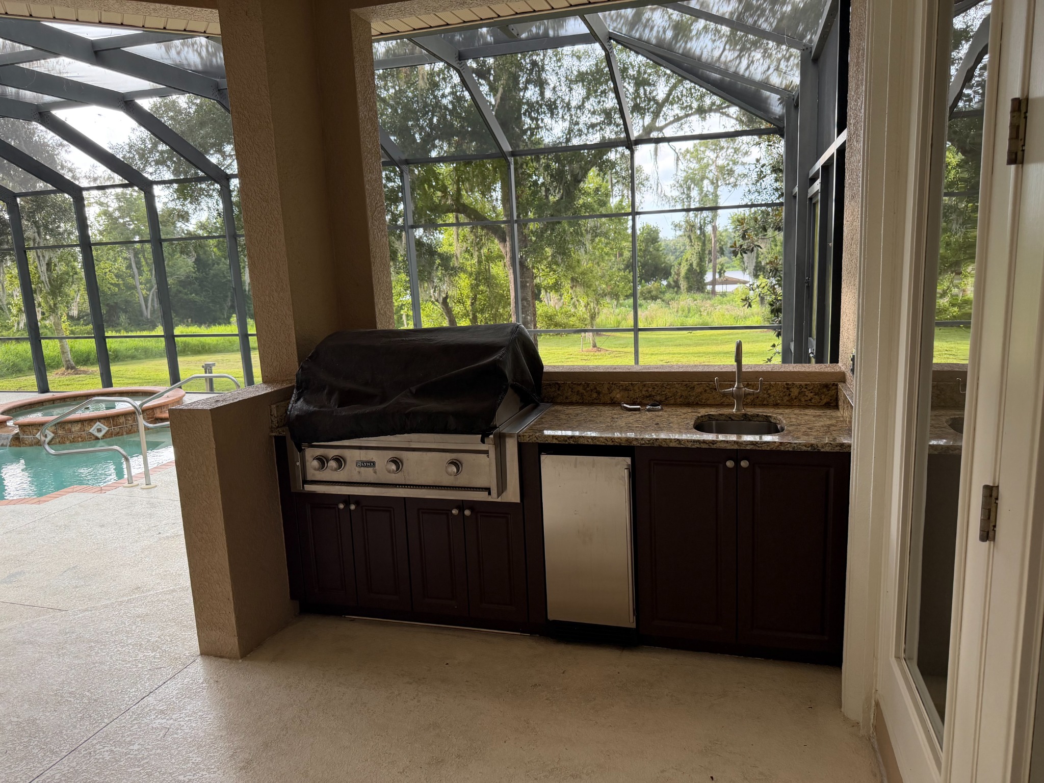 Screened outdoor kitchen beside the pool